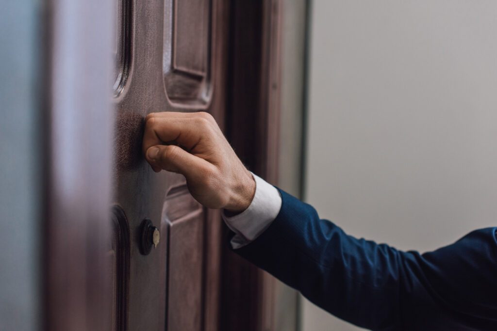 Cropped view of hand knocking on door