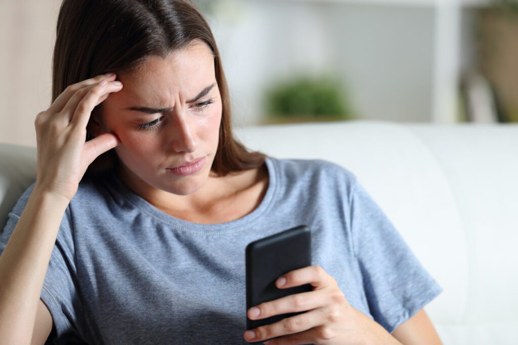 Confused Woman Checking Phone At Home