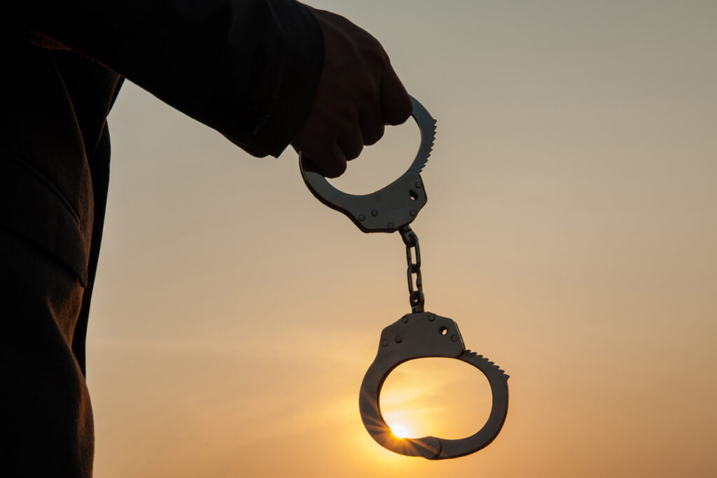 Man holding handcuffs after releasing over sunset background