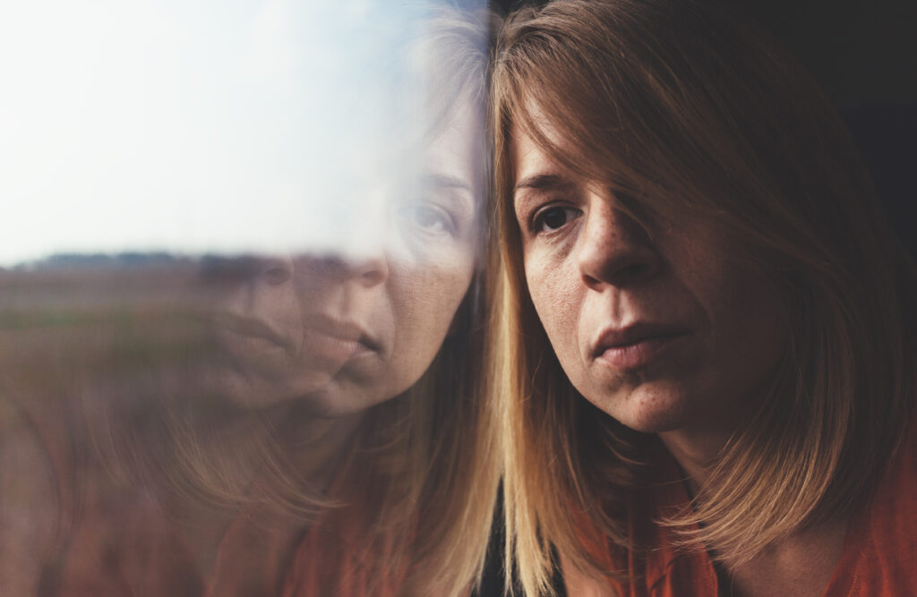 Woman Looking Out The Window Lost In Thought