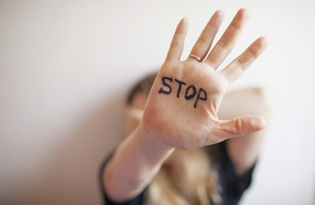 Woman shows palm with the inscription on the palm "Stop"