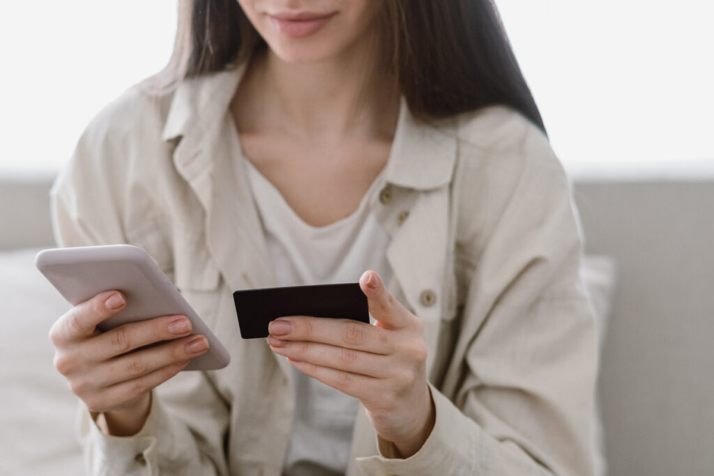 Woman holding a mobile phone and credit card donating money to charity